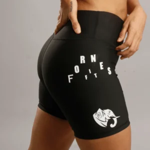 Primer plano lateral de mujer usando biker shorts negros de alta compresión con logotipo de elefante y tipografía Fit Fornes en blanco.