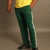 Hombre usando pantalón deportivo verde con franjas laterales beige y logotipo Fit Fornes, ideal para gimnasio y estilo casual.