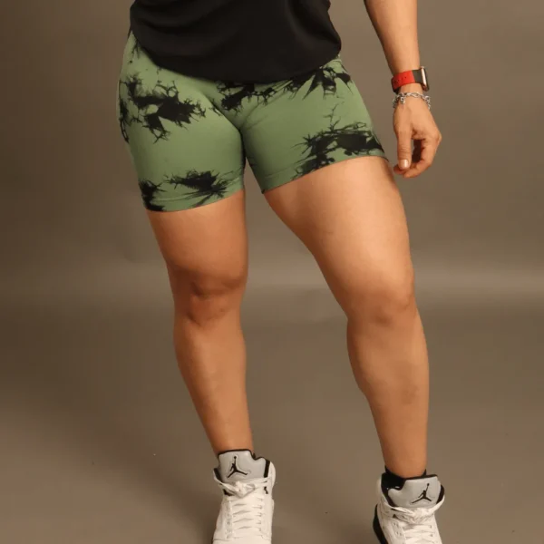 mujer en plano frontal usando biker shorts con diseño tye-dye verde musgo y negro de Fit Fornes, resaltando el ajuste de compresión.