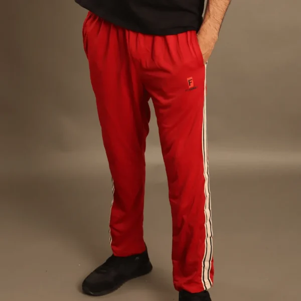 Hombre usando pantalón deportivo vinotinto con franjas laterales beige y logotipo Fit Fornes, ideal para gimnasio y estilo casual.