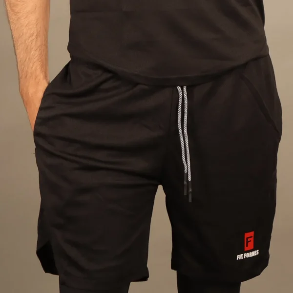 Hombre usando short deportivo 2 en 1 color negro licra de compresión blanca interna y logotipo Fit Fornes.