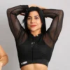 Mujer posando con crop top de malla negra transparente, capucha y mangas largas con logotipo Fit Fornes en la cintura.