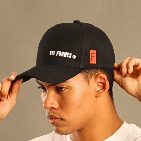 hombre usando una gorra deportiva negra de Fit Fornes con logotipo blanco bordado en el frente y detalle rojo lateral.