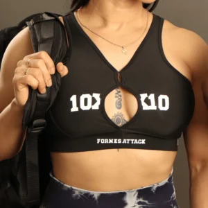 top-deportivo-fornes-attack-10x10-negro.jpg Primer plano de un top deportivo negro para mujer con el logotipo "10x10 Fornes Attack" y detalle de apertura central en el pecho.