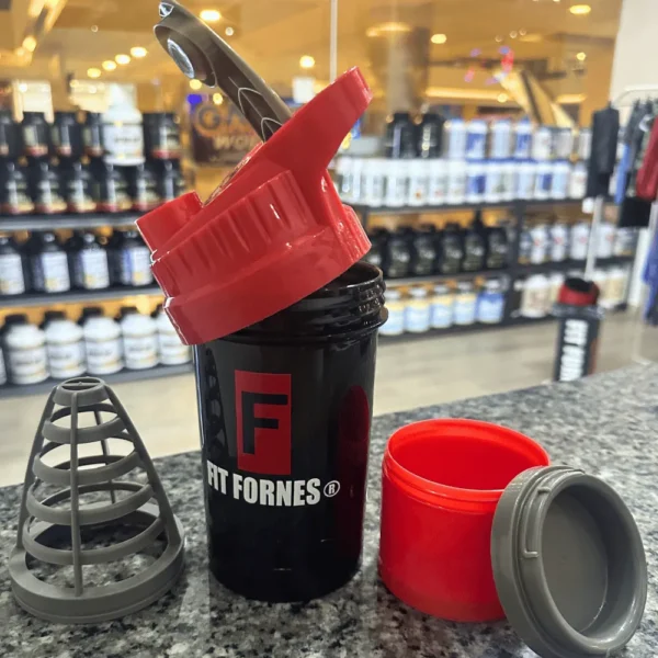 mezclador Fit Fornes en color rojo sobre un mostrador de granito en una tienda de suplementos.