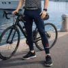 Hombre en el muelle despues de ir a pasear en bicicleta usando leggings de compresión negros Pro Combat con el logotipo rojo de Fit Fornes en el tobillo y banda elástica en la cintura.
