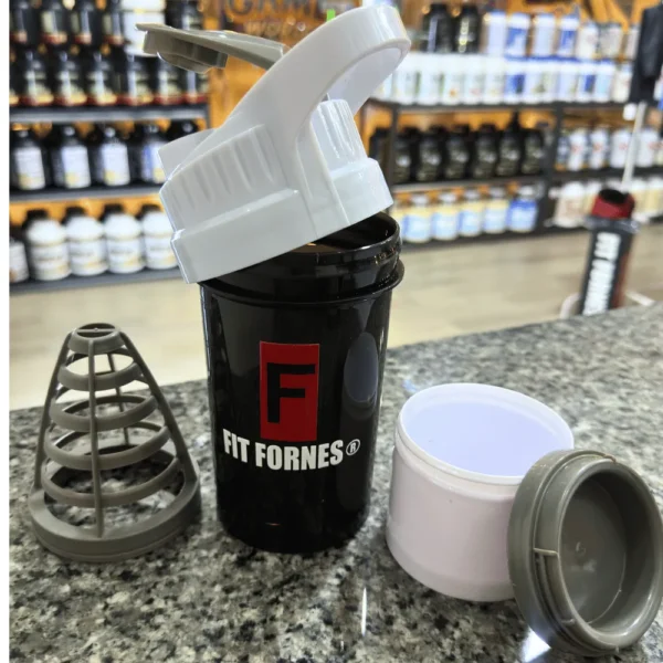 mezclador Fit Fornes en color blanco sobre un mostrador de granito en una tienda de suplementos.